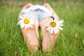 Child feet with daisy flower. Kid having fun at spring nature. Holiday Royalty Free Stock Photo