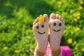 Child feet on the grass drawing a smile. Selective focus. Royalty Free Stock Photo