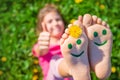 Child feet on the grass drawing a smile. Selective focus. Royalty Free Stock Photo