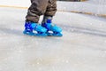 Child feet learning to skate on ice in winter Royalty Free Stock Photo