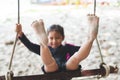 Child feet with sand while she playing on a swing at the beach near the sea in vacation Royalty Free Stock Photo