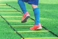 Child soccer boots training on agility speed ladder in soccer training Royalty Free Stock Photo