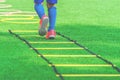 Feet with soccer boots training on agility speed ladder in soccer training