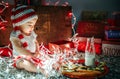 Child in Festive Knit Hat Playing with Christmas Lights with Milk and Cookies and Carrot for Santa and Reindeer