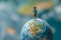 Child figurine atop Earth model Royalty Free Stock Photo