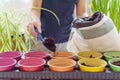 Child fills colorful pots with earth for growing seedlings and plants at home
