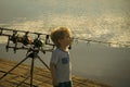 Child is fishing. Boy stand on fishing pier Royalty Free Stock Photo