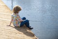 Child fishing at river or lake. Young kid fisher. Summer outdoor leisure activity. Little boy angling at river with rod. Royalty Free Stock Photo