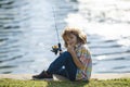 Child fishing at river. Young kid fisher. Summer outdoor leisure activity. Little boy angling at river bank with rod. Royalty Free Stock Photo