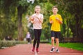 Child fitness, twins kids running on stadium track in city park , training and children sport healthy lifestyle. Outdoor Royalty Free Stock Photo