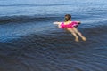 Child floating with an inflatable lap on the sea won. Back view