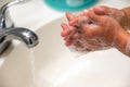 A child folding hands while washing with soap