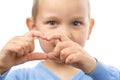 Child folding his fingers in a symbol of love.