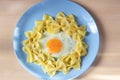 Child food. Funny food. Plate with pasta with fried egg in the form of funny face sun. Children`s menu and lunch concept. Flat Royalty Free Stock Photo