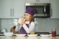 Child food preparation. Chef kid boy in apron and chef hat cooking at kitchen. Healthy food. Royalty Free Stock Photo