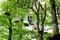 Child in forest adventure park. Kid boy in helmet climbs on high rope trail. Agility skills and climbing outdoor Royalty Free Stock Photo