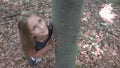 Child in Forest, Kid Playing in Nature, Girl in Adventure Outdoor Behind a Tree