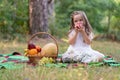 Child on forest picnic eating apple. Toddler kid in sunny park or garden. Little girl enjoying leisure.