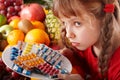 Child with fruit and vitamin pill. Royalty Free Stock Photo