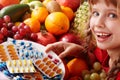 Child with fruit and vitamin pill. Royalty Free Stock Photo