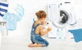 Child fun happy little girl to wash clothes and teddy bear in l Royalty Free Stock Photo