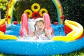 Child in garden swimming pool with slide Royalty Free Stock Photo