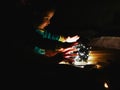 Child and garland in the dark. little child holds shiny christmas lights indoors close dark background. Portrait of a happy kid