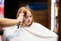 Child getting haircut. Hairdresser cutting hair Royalty Free Stock Photo