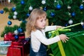 A child with a gift in the hands near the Christmas tree