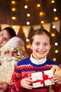 Child girl accepting gifts from Santa near decorated xmas tree with lights, they talking and smiling - Merry Christmas and Happy Royalty Free Stock Photo