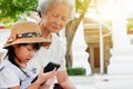 Child girl is addictive, have an elderly grandmother sit Royalty Free Stock Photo