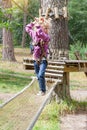 Child girl in adventure climbing high wire park, active lifestyle of children