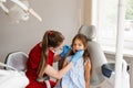 Child girl afraid dentist. Childrens dentist consults frightened kid in dentistry. Treatment of teeth and toothache in