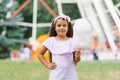 Child girl in an amusement park in the summer eats cotton candy and smiles happily. The concept of summer holidays and school holi