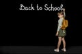 Child girl with backpack writing on the blackboard with brush. Back to school, study, education, success concept Royalty Free Stock Photo