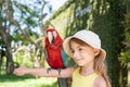 child girl with beautiful macaw parrot in her shoulder in the zoo, Bali, Indonesia