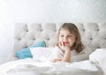 Child girl in a bed happy face. Little girl sensual portrait. Good morning. Toddler in a good mood. Good sleep. Kid in bedroom