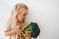 Child girl with broccoli healthy food vegan eating lifestyle organic vegetables vitamins plant based diet Royalty Free Stock Photo