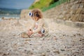 Child girl building stone tower on the beach in summer day Royalty Free Stock Photo