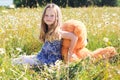 Child girl in camomile field with teddy bear Royalty Free Stock Photo