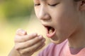 Child girl checking breath with her hand,woman doing a bad breath test after have breakfast,foul mouth from inside the tongue,