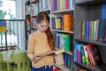 Child girl choosing book in school library. School education. Benefits of everyday reading