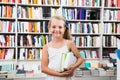 Child girl chose a lot of books in the library Royalty Free Stock Photo