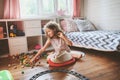 Child girl cleaning her room and organize wooden toys into knitted storage bag Royalty Free Stock Photo