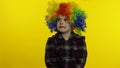 Little child girl clown in colorful wig making silly faces, having fun, smiling, dancing. Halloween Royalty Free Stock Photo