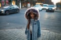 Child girl is standing at the sidewalk on background of city street in evening. Royalty Free Stock Photo