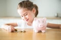 Child girl counting money with a piggy bank Royalty Free Stock Photo