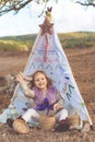 Child girl in decorative hovel on the nature