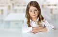 Child girl at desk in classroom background empty space.