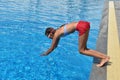 Child girl dives into the pool. Girl learning to swim autdoor. Swimming pool in the hotel. Children swim in the outdoor pool.